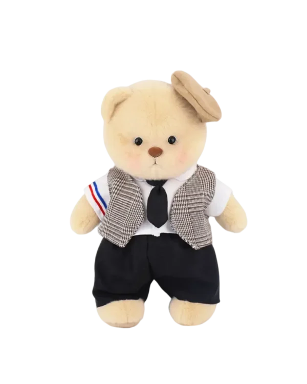 petit nounours brun en costume de mariage.il a son petit chapeau sur la tête. Il est debout et vue de face