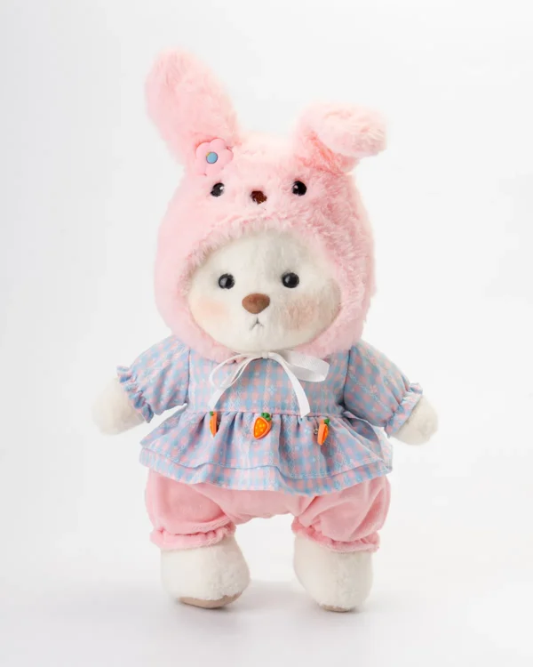 Ourson blanc en peluche portant une robe délicate et un chapeau inspiré d’un lapin