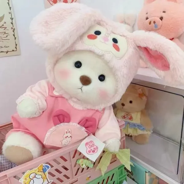 cet adorable petit ourson est habillé en salopette rose et porte un chapeau en forme de lapin
