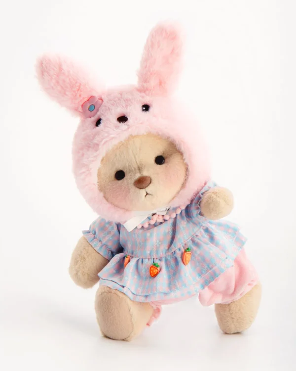 Ourson tout doux avec sa robe élégante et son chapeau de lapin rose debout et qui prend la pose