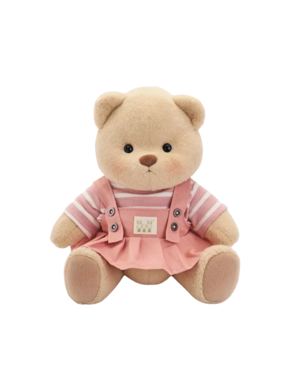 petit nounours brun en robe salopette rose assis