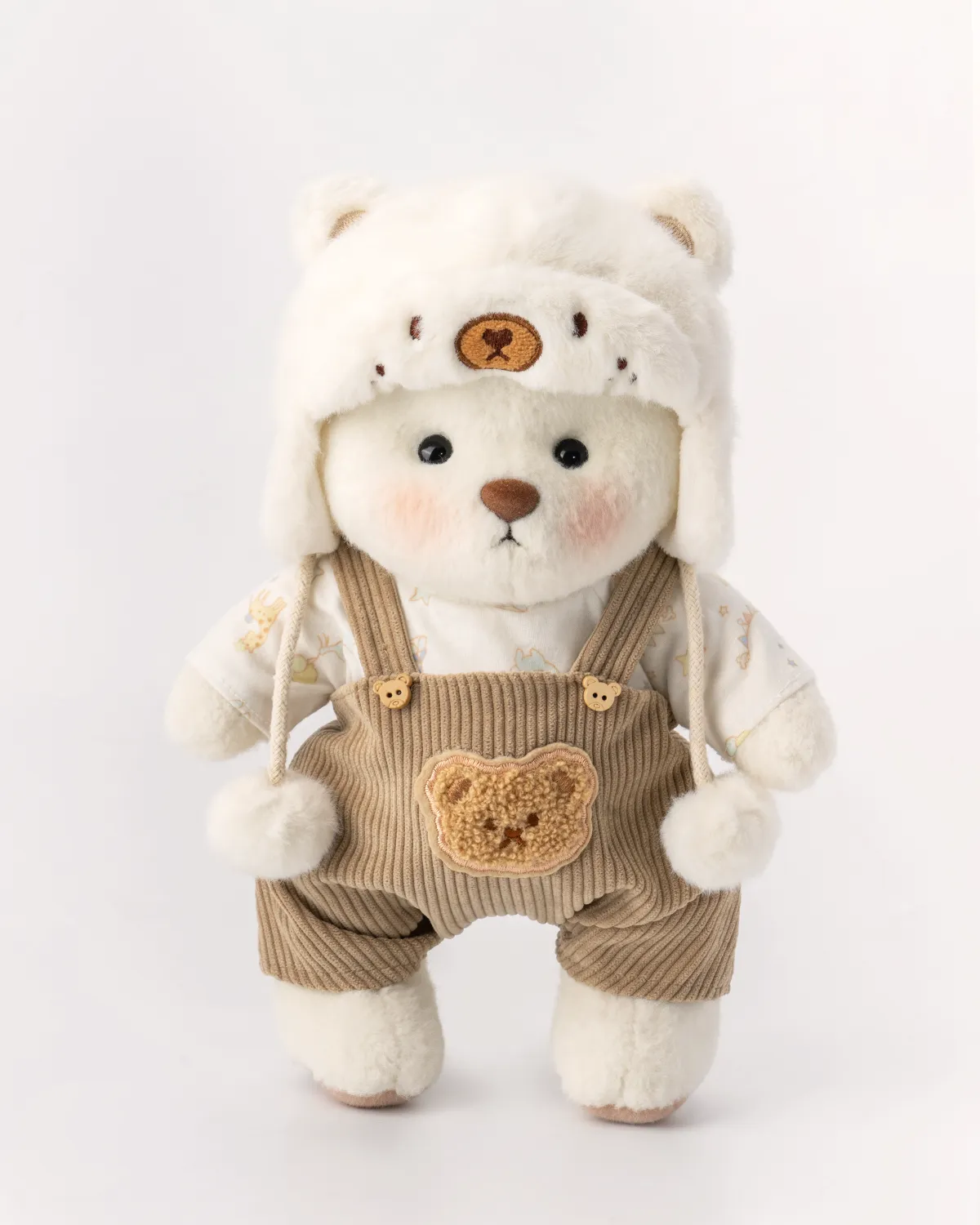 Petit nounours blanc en salopette marron et chapeau blanc 3 magnifique ourson en salopette marron et sa petite tête est couverte d'un jolie chapeau blanc. il est debout de face.