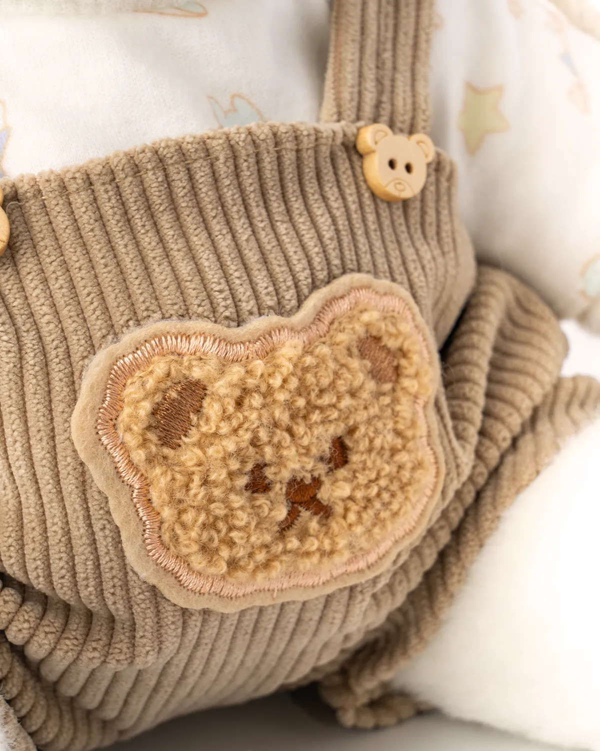 Petit nounours blanc en salopette marron et chapeau blanc 5 vue de près de la belle salopette marron