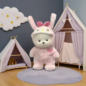 Peluche à habiller Petit Nounours blanc déguisé en lapin rose dans une chambre d'enfant