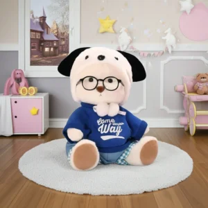 Peluche à habiller Petit Nounours blanc en pull bleu et lunettes noires, un ours en peluche dans une chambre d'enfant