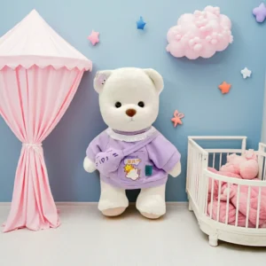Ours en peluche Petit Nounours blanc en pull mauve, une peluche à habiller dans une chambre d'enfant