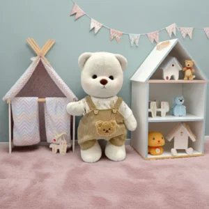Ours en peluche Petit Nounours blanc en salopette marron, une peluche à habiller dans une chambre d'enfant
