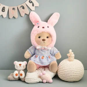 Peluche à habiller Petit Nounours brun en robe et chapeau de lapin, un ours en peluche dans une chambre d'enfant