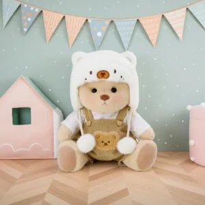 Ours en peluche Petit Nounours brun en salopette marron et son chapeau blanc, une peluche à habiller dans une chambre d'enfant