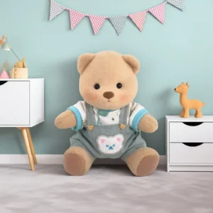 Peluche à habiller Petit Nounours brun en salopette verte et t-shirt dinosaure, un ours en peluche dans une chambre d'enfant